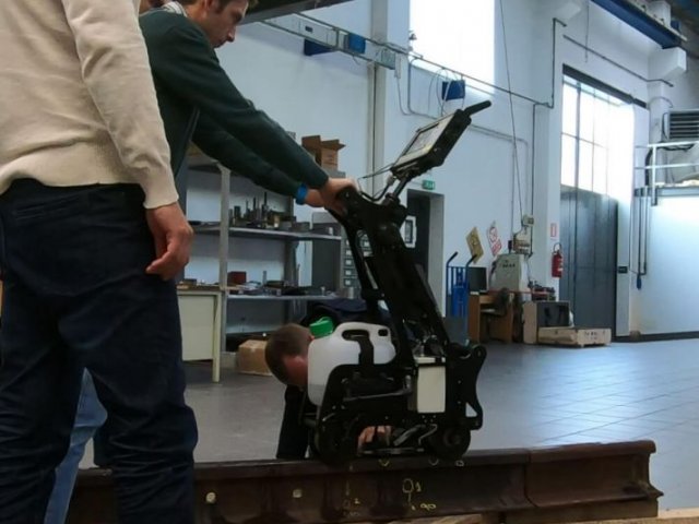 Foreign customer gets trained how to operate the ultrasonic flaw detector UDS2-77 on a rail sample — on-site training in Italy, November 2019