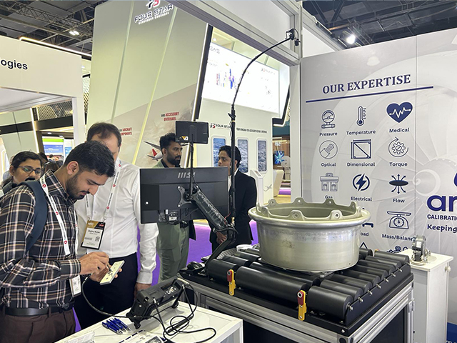 Visitante del estand de OKOndt GROUP trabaja con un escáner rotativo para orificios de pernos, feria de MRO en la aviación, Dubái, 2026