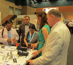 Indian specialists at the booth of Promprylad companyAttendees of WCNDT-2012 look at the devices represented at OKOndt GROUP booth