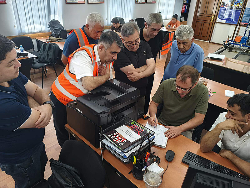 Metro railway maintenance engineers gathered around an OKOndt GROUP instructor during practical training on ultrasonic metro rail flaw detection technology